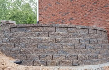 retaining wall by a red-brick house