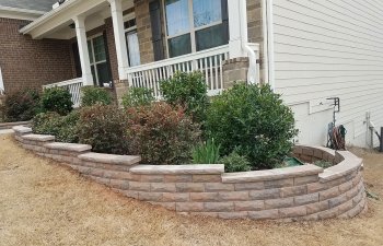 retaining walls surrounding plants in front of a house