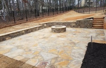 flagstone patio with a fire pit and retaining walls